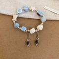 Blue beaded bracelet with marble texture stones and pinecone charm in a vintage style - Blue-Pinecone
