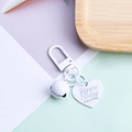 Dettaglio di un portachiavi a cuore bianco in lega con campanello e targhetta incisa - Bianco