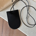 Detail of a minimalist black faux leather magnetic glasses holder pendant on linen cloth - Black Key Bag Necklace