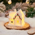 Miniature white Christmas house with glowing lights and snowy roof on wooden base - Snow House D
