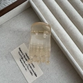 Close-up of a 5cm beige resin hair claw clip in a linen jewelry tray for high ponytail - Jelly Champagne