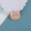Cute brown cartoon bear acrylic pin with yellow bow on a blue background - Winking Bear Head