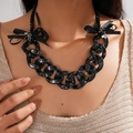 Dettaglio della collana a catena nera maculata con fiocchi in tessuto e ciondoli a stella - Collana / Collana-Nero