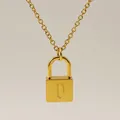 Minimalist gold necklace featuring a padlock pendant with an artistic V letter engraving - Style Letter V