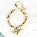Close-up of golden beaded bracelet with a sparkling zircon-encrusted letter H charm - Letter H