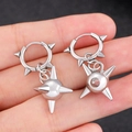 Close-up of punk style silver earrings featuring spiked ball charms and metallic hoops - White K Spiky Ball Ear Buckle (DZ-187)