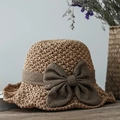Chapeau de paille naturel avec un grand nœud marron foncé sur une table en bois rustique - café