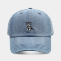 Dettaglio del ricamo a forma di cane su un cappellino da baseball in denim blu lavato - Regolabile / Azzurro