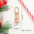 Detailed view of enamel snowman keychain with faux pearl and festive pine decoration - Snowman