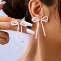 Eleganti orecchini a perno a forma di fiocco con perle bianche e dettaglio in metallo oro - Orecchini a Bottone con Perla e Fiocco (ER24Y0073)