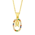 Macro view of gold pendant featuring micro-pave letter M with colorful zircon stones - M