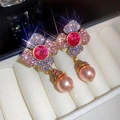 Macro detail of vintage floral tassel earring with pink rhinestones and pearls - Purple & Rose Red
