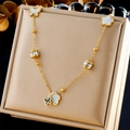 Dettaglio della collana dorata con ciondoli a farfalla e fiori bianchi in scatola - Set di Gioielli in Madreperla con Fiori e Farfalle Oro (N1949)