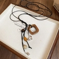 Detailed shot of retro pendant necklace with wooden beads and silver heart charm on black cord - 17# Brown Necklace