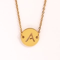 Macro detail of gold round coin necklace with hollowed letter A pendant on white background - Letter A