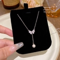 Collana elegante con ciondolo a farfalla e perle su un supporto nero di lusso - Stile pendente con perla e strass a farfalla (X577) / Argento