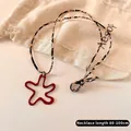 Detail of red star pendant with leopard print cord on a stylish sweater necklace - Brown Leopard Rope Red Star Style
