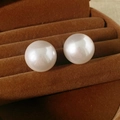 Macro shot of large round white pearls on brown velvet tray showing lustrous texture - Silver Pin - Champagne - Medium