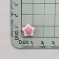Draufsicht auf 1,2cm zweifarbigen Stern-Harzanhänger auf einer grünen Schneidematte - Rosa