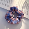 Red and blue plaid scrunchie with twill fabric texture on a minimalist white desk - Artistic Girl Cool Summer