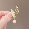 Detalle de broche de hoja en oro de 18K con nácar blanco y colgante de perla redonda - Oro-Blanco