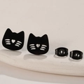 Macro shot of black stainless steel cat earrings with heart cutout on stone display - Cat / Black