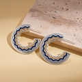 Detail von silbernen C-förmigen Wellen-Ohrringen mit dunkelblauem und beige Emaille - Blau (Silberner Ohrringstecker)