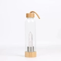 Bamboo lid glass water bottle with natural white crystal point and woven carry strap - Clear Quartz Bottle