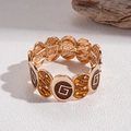 Dettaglio macro del bracciale elastico retrò dorato con resina ambrata e motivi a stella - Base Oro Smalto Marrone