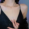 Détail d'un collier en Y doré élégant avec perles sur le cou d'un mannequin - Doré