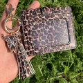 Detailed close-up of leopard print PU leather card holder with tassel and bull head charm - Red Leopard