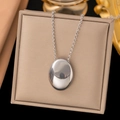 Minimalist silver oval pendant necklace in polished finish on jewelry box - Geometric Oval / Steel