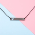 Close-up of black bar necklace with hollow heart detail on a modern two-tone background - 18 inch / Black