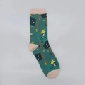 Detail of green cotton socks featuring jacquard trees and a cyclist illustration - One Size / Tree