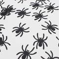 Scattered black plastic spiders Halloween party table confetti decorations on white background - Black Spider