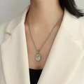 Silver Figaro chain necklace featuring an oval coin pendant with embossed floral pattern - P1023 Steel Silver Plum Blossom Tulip