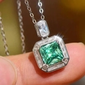 Detailed close-up of emerald-cut green gemstone necklace with rectangular halo setting - White Gold