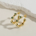 Detail of 14K gold plated C-shape wave earrings with green zircon stones on mineral stone - Green Zirconia Wavy-Gold