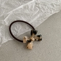Elastic hair tie in dark brown with amber acrylic bow ornament on stone surface - Light Tortoiseshell