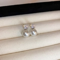 Vue macro de boucles d'oreilles en perles avec zircons sur un plateau à bijoux beige - 17# Tige d'oreille en argent sterling 925 Perle blanche argent