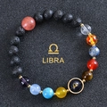 Zodiac Libra bracelet featuring blue sandstone and natural lava rock beads on black background - Libra