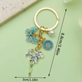 Charming gold-tone keychain with blue butterfly daisy and iris flower charms - Blue Butterfly Pearl Iris (ER1541)