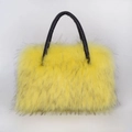 Detail of fluffy yellow faux fur texture on a high-end tote bag with a black leather handle - Yellow