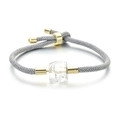 Détail d'un bracelet tissé gris ajustable avec cristal facetté clair et accents dorés - Cristal de Roche / Corde Grise