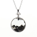 Macro shot of circular silver pendant with polished black natural stone chips - Silver + Obsidian
