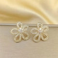Close-up of gold flower earrings with pavé crystals on a luxury beige leather background - Stud Earrings / Gold