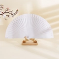 Minimalist white solid wood folding fan on a wooden stand with artistic leaf shadows - White