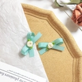Dettaglio di fermagli per capelli a fiocco azzurro con piccoli fiori bianchi in tessuto - Blu Ottanio