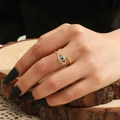 Detail van gouden evil eye ring met blauwe zirkonia en steraccenten aan hand - Goud-Lash Evil Eye (Met Stersteen)