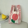 Close-up of pink knit tote bag with red peach pattern and soft woven texture details - Tulip Pink